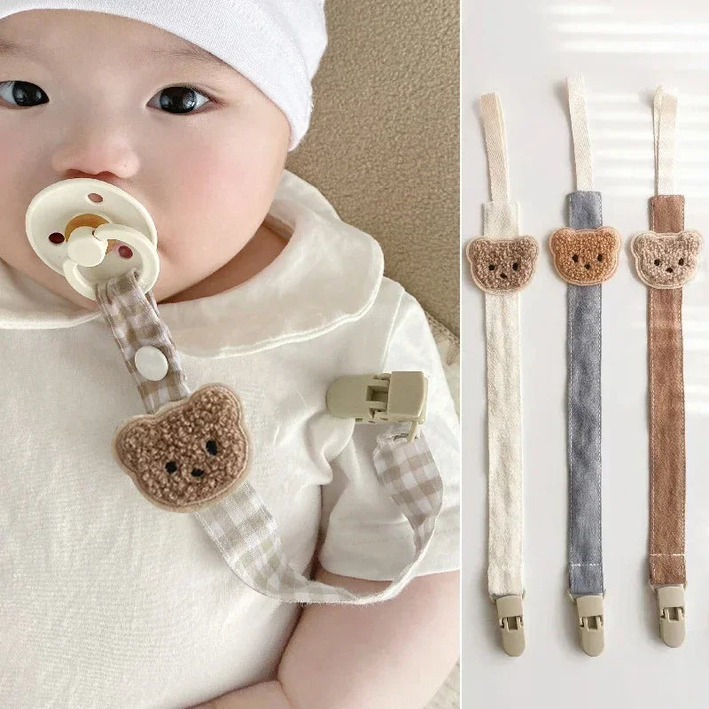 Lullary Hush Pacifier Clip in cotton and wood on beige linen